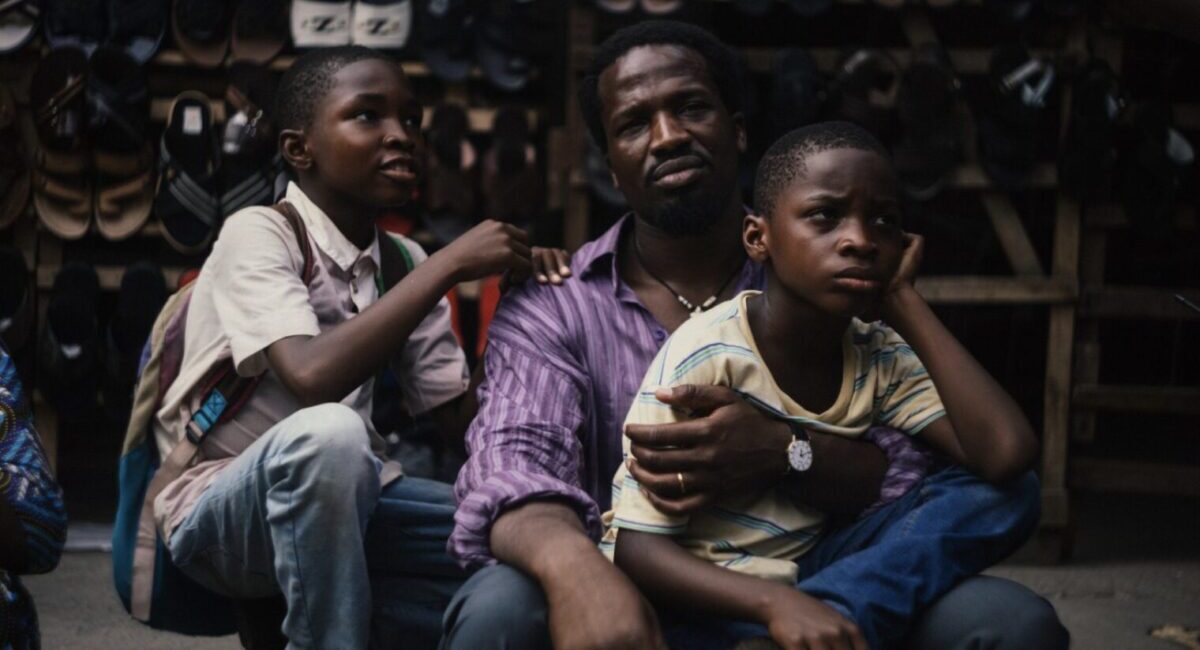 Man with two children sitting on sidewalk